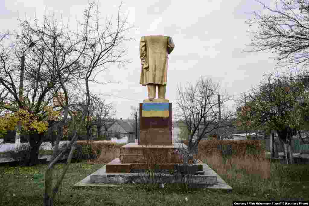 A headless Lenin stands in Shabo, spray-painted with the colors of the Ukrainian flag.