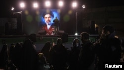 A photo of Mojtaba Khamenei is displayed on a screen in Tehran after he was named supreme leader.