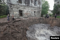 Police work near a crater at the site of hospital buildings damaged by a Russian missile strike in Kharkiv on April 27.