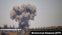 Smoke rises above opposition held areas of the Daraa province countryside during airstrikes by Syrian regime forces, June 27, 2018