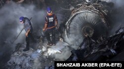 Rescue workers search for survivors amid the wreckage of the passenger plane that crashed in Karachi on May 22.