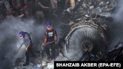 Rescue workers search for the bodies or survivors amid wreckage of a passenger plane of state-run Pakistan International Airlines after it crashed in residential part of Karachi on May 22.