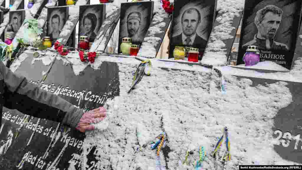 Një person largon borën nga memoriali, ku është shkruar dedikimi për personat e vrarë gjatë protestave anti-qeveritare të vitit 2014. &nbsp;
