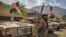 Armed men supporting the fight against the Taliban stand with their weapons and Humvee vehicles in Bazarak in Afghanistan's Panjshir Province on August 19. 