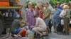 Residents wait in line to collect water delivered by a tank truck in Donetsk on July 29.
