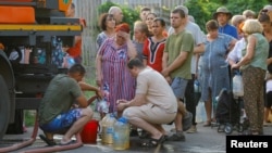 Stanovnici čekaju u redu da prikupe vodu koju je dostavila cisterna u Donjecku 29. jula.