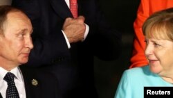 Russian President Vladimir Putin (left) and German Chancellor Angela Merkel speak in China in September