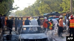 Firefighters douse a car at the suicide blast site in Islamabad on November 11, 2025, after a suicide bombing outside district court buildings killed 12 people and wounded 27 others.