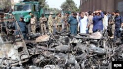 Afghan security officials inspect the scene of a bomb blast outside the Great Mosque in Herat on June 6.