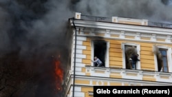 Людзі ратуюцца ў ваконных праёмах ад пажару пасьля атакі на Акадэмію Навук Украіны