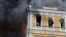 Людзі ратуюцца ў ваконных праёмах ад пажару пасьля атакі на Акадэмію Навук Украіны