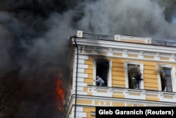 Люди у вікнах будівлі Національної академії наук України. Вирує пожежа, що виникла внаслідок удару російського БПЛА по НАНУ. Київ, середина дня 28 вересня 2026 року
