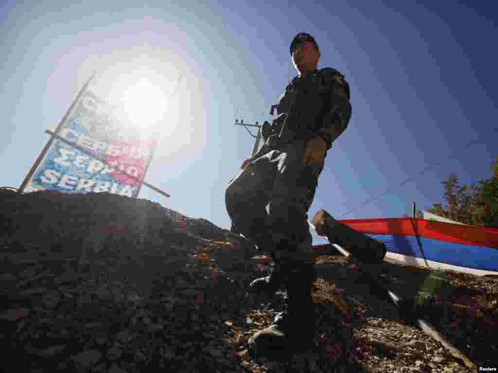 A NATO Kosovo Force (KFOR) soldier from France walks along barricades at the closed Serbia-Kosovo border crossing of Brnjak. (Marko Djurica for Reuters)