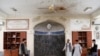 Men inspect the site of a blast inside a mosque in Kabul on June 12.