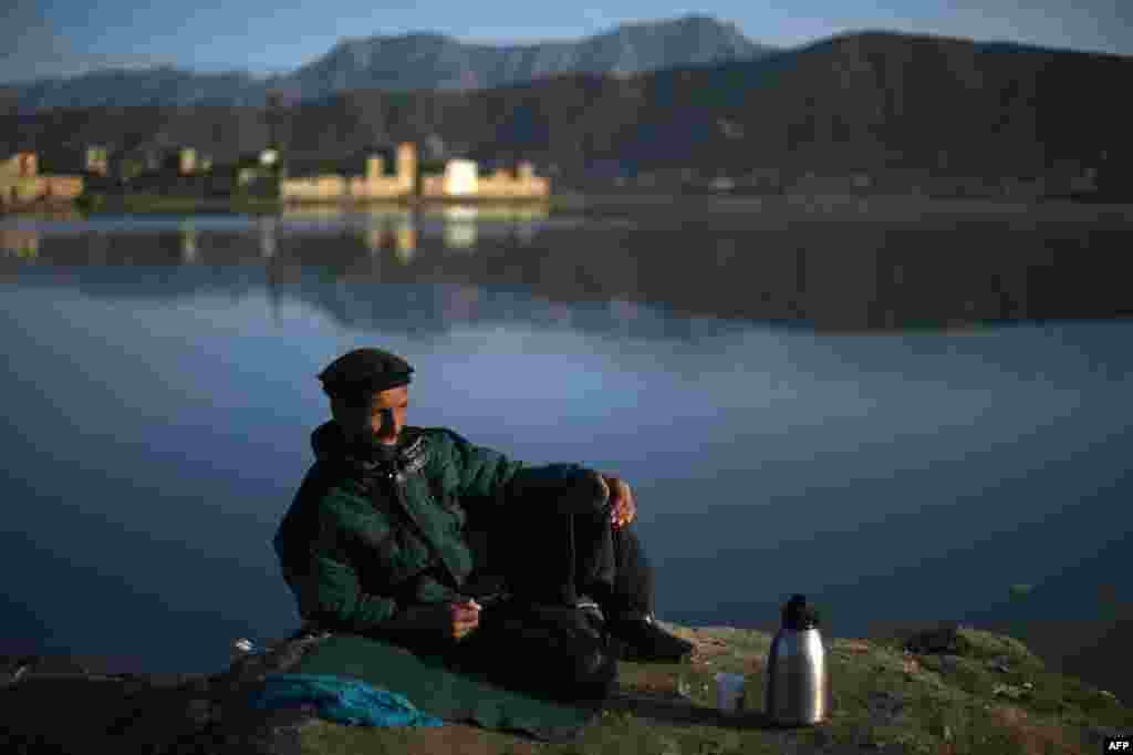 An Afghan car-wash worker waits for customers beside Shuhada Lake in Kabul. (AFP/Wakil Kohsar)