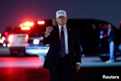 US President Donald Trump pumps his fist after disembarking Air Force One in Florida late on February 27.