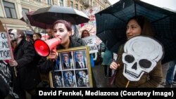 Вара Міхайлава з карцінай «Дзевяць стадый гніцьця правадыра» на шэсьці ў Пецярбургу. Фота: Давід Фрэнкель, «Медиазона»