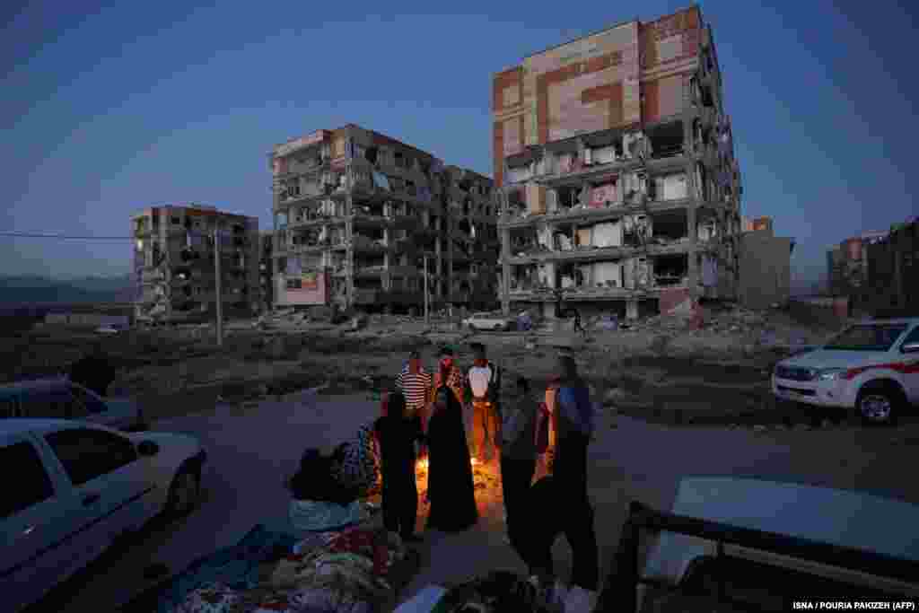 Residents huddle by a fire in an open area following a 7.3-magnitude earthquake at Sarpol-e Zahab in Iran&#39;s Kermanshah Province on November 13. (AFP/ISNA/Pouria Pakizeh)