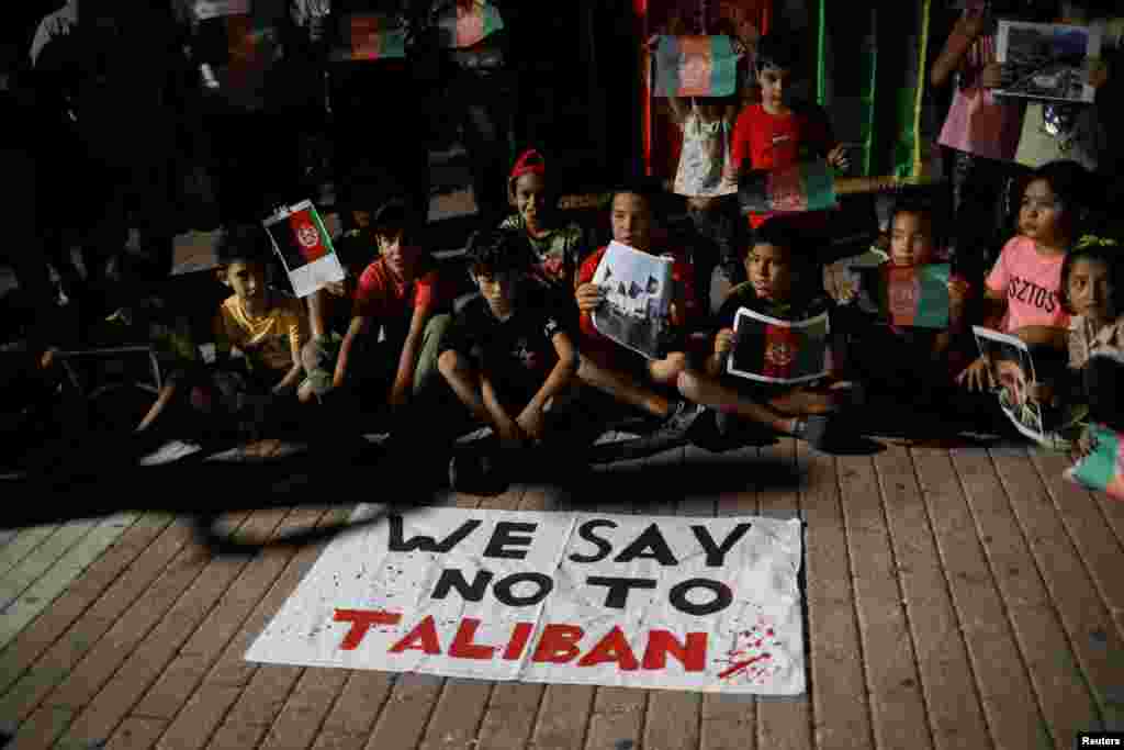 Афганистански мигранти на гръцкия остров Лесбос протестират срещу превземането на Афганистан от талибаните. Деца са насядали зад плакат, на който е изписано &quot;Ние казваме &quot;не&quot; на талибаните&quot;.