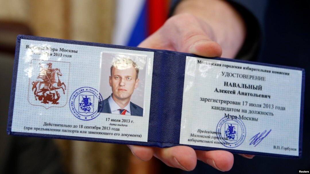 Valentin Gorbunov, the head of Moscow's City Election Commission, holds the candidate registration certificate of Aleksei Navalny at the Moscow mayor's office on July 17.