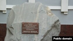 Төмәндә элекке НКВД бинасы ишек алдында сәяси золым корбаннары күпләп юк ителгән урында истәлек билгесе. 