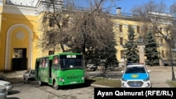 Пустой маршрутный автобус и автомобиль полиции у здания Академии наук, недалеко от места митинга. Алматы, 27 марта 2021 года.