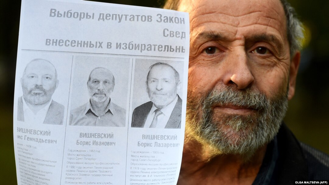 Пратеникот Борис Вишневски од партијата Јаболко со предизборен леток на кој се и неговите двајца „двојници“, но од владејачката партија