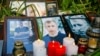 UKRAINE -- Candles are placed next to the portraits of Vital Shyshou, a Belarusian activist living in exile who was found hanged in a park near his home this morning, during a commemoration rally next to the Belarusian Embassy to Ukraine in Kyiv, August 3