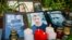 UKRAINE -- Candles are placed next to the portraits of Vital Shyshou, a Belarusian activist living in exile who was found hanged in a park near his home this morning, during a commemoration rally next to the Belarusian Embassy to Ukraine in Kyiv, August 3