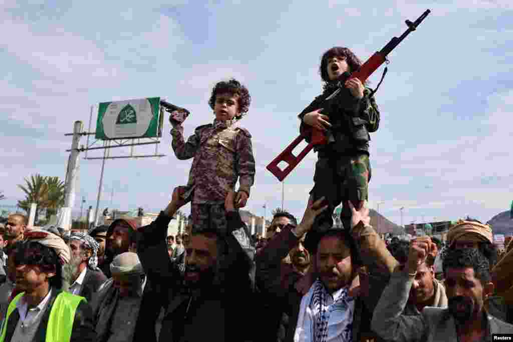 Мальчик выкрикивает лозунги, держа в руках игрушечный пистолет, а другой мальчик с пистолетом в руках наблюдает за ним во время демонстрации в знак солидарности с Ираном в Сане, Йемен, 27 марта 2026 года. REUTERS/Халед Абдулла