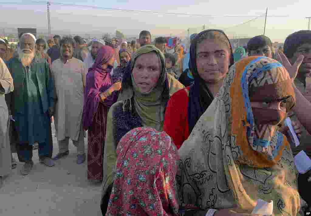 Afghan families gather to receive food distributed by an Islamabad-based Christian organization on the outskirts of Chaman, a border town in Pakistan&#39;s southwestern Balochistan Province, on August 31.