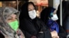 Commuters wear masks to help guard against coronavirus on a public bus in downtown Tehran, February 23, 2020