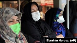 Commuters wear masks to help guard against coronavirus on a public bus in downtown Tehran, February 23, 2020