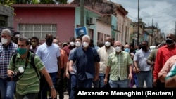 Президент Куби Мігель Діас-Канель (у центрі) в день початку протестів, 11 липня, перебував у містечку Сан-Антоніо-де лос-Баньйос