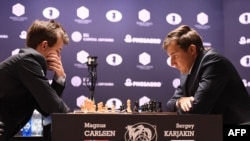 World chess champion Magnus Carlsen of Norway and challenger Sergei Karjakin of Russia concentrate during Game 1 of their match on November 11.