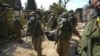 Soldați israelieni transportă cadavrul unei persoane ucise în atacul Hamas din kibbutzul Kfar Aza, din apropierea Fâșiei Gaza, Israel, marți, 10 octombrie 2023.