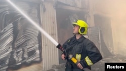 An image provided by Ukraine's emergency services shows a firefighter working at storage facilities that were hit during Russian missile and drone strikes on Odesa on July 19. 