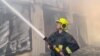 Ukrajinski vatrogasac gasi požar na skladištu nakon ruskih zračnih i napada dronom na Odesu, 19. juli 2023.