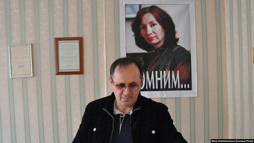Оюб Титиев на фоне портрета убитой в Чечне коллеги Натальи Эстемировой
