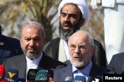 Iranian Parliament Speaker Mohammad Baqer Qalibaf (right) delivers a speech at the site where Iranian military commander Qasem Soleimani and Iraqi paramilitary commander Abu Mahdi al-Muhandis were killed in a US drone strike, in Baghdad on August 19.