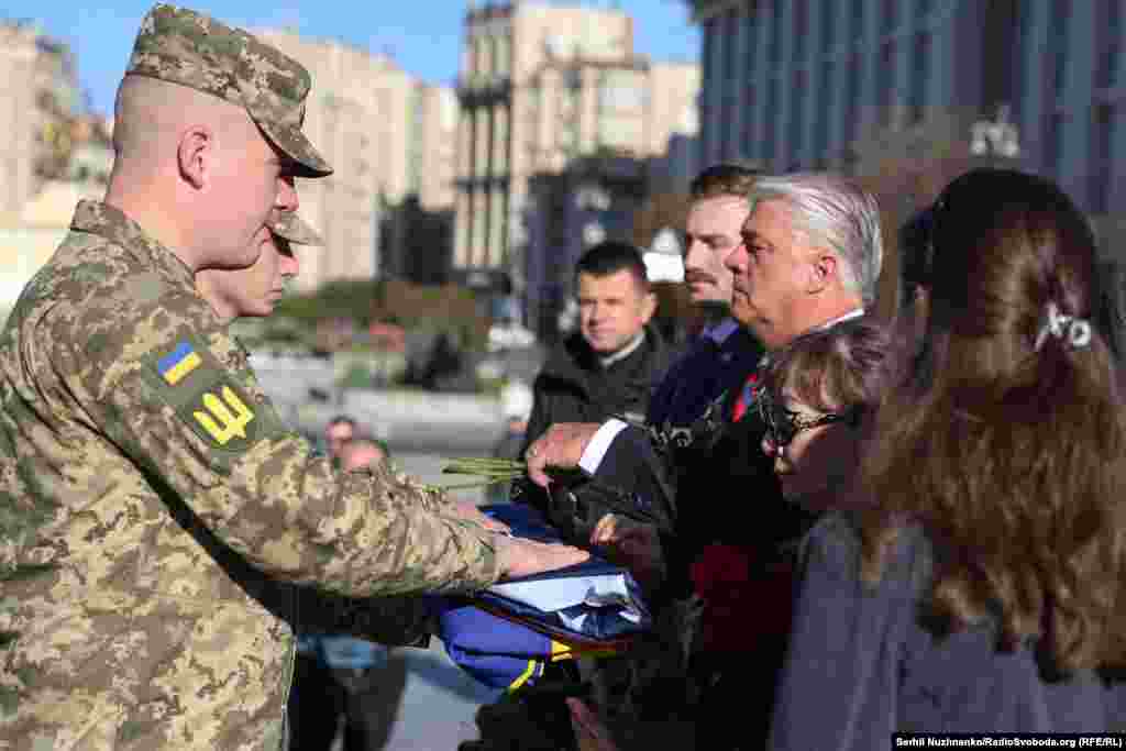 Почесна варта передає родинам прапори України і США, якими були вкриті домовини