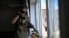 Украинский военный у окна поврежденной российскими обстрелами многоэтажки в Дружковке, Донецкая область, 25 августа 2026 года