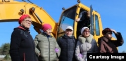 Люди стоят перед бульдозером, пытаясь защитить могилу Яши Степанова