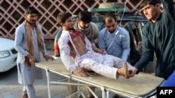 Volunteers carry an injured man on a stretcher to a hospital following the suicide bombing in Nangarhar on June 16.