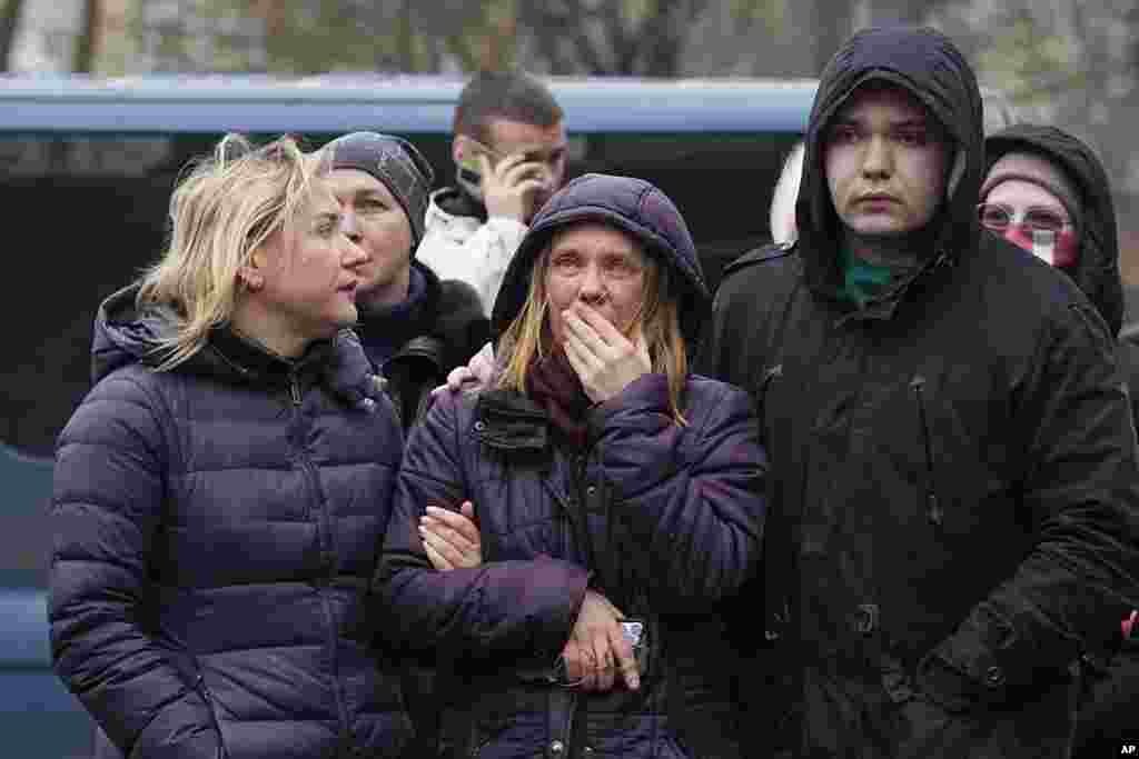 Residents watch as emergency personal work to extinguish fires at the multistory residential building. &nbsp;