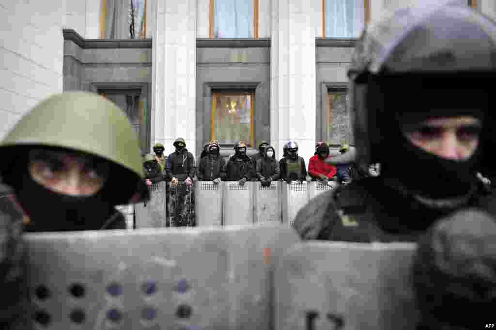 Antigovernment activists stand guard outside the parliament during a session.