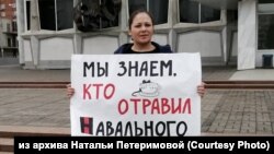 Активистка Наталья Петеримова с плакатом, по надписи которого проводил "экспертизу" Данила Михеев