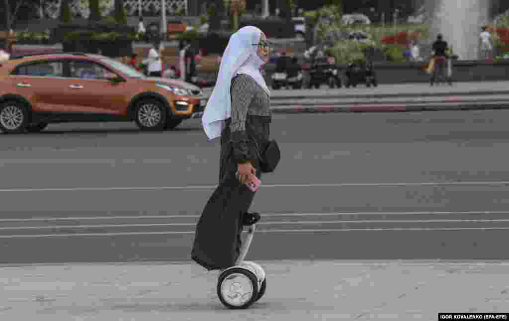 Кыргызская женщина едет на сегвее в центре Бишкека
