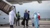A specialist wearing protective gear sprays disinfectant after the arrival of a plane carrying Kyrgyz citizens from Japan and South Korea in Almaty on May 14.
