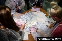 A helyi választási bizottság tagjai kiürítik az urnákat és szétválogatják a szavazólapokat a további számláláshoz vasárnap, a háromnapos parlamenti választás első napján a távol-keleti Vlagyivosztokban, 2021. szeptember 17-én
